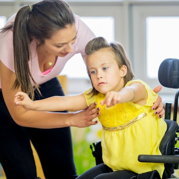 Physical therapist helping a child out of her wheelchair