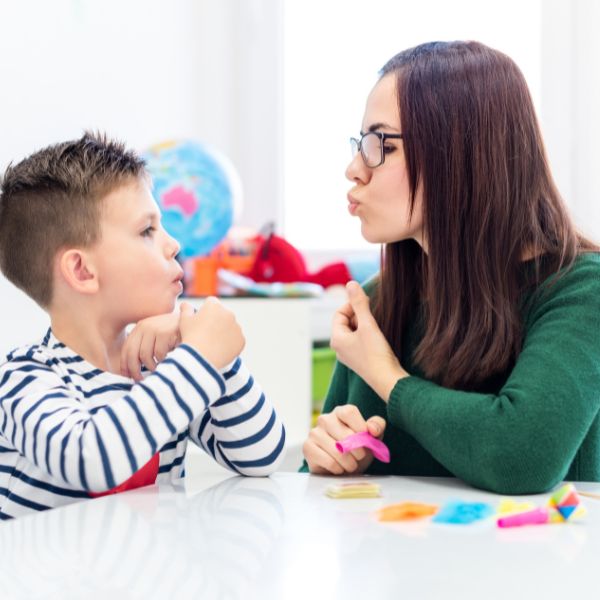 speech therapist showing a child how to make a sound